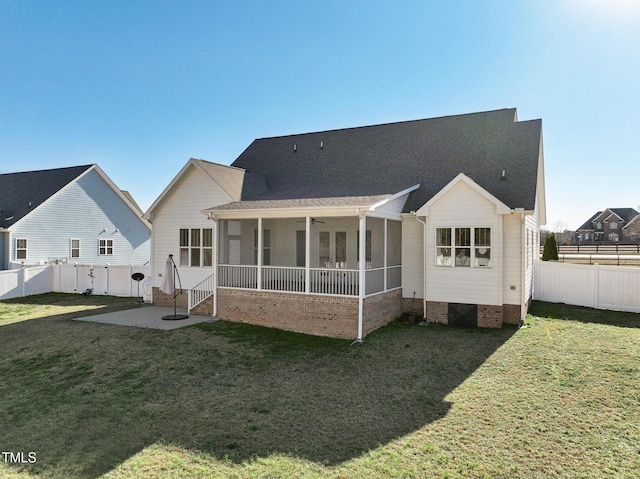 back of property with ceiling fan, a patio, a sunroom, and a lawn