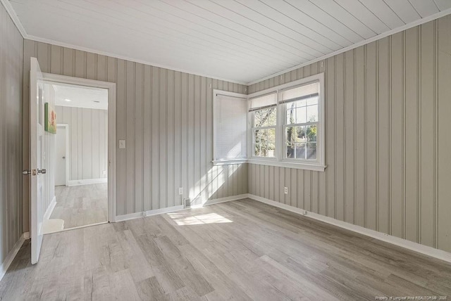 empty room with crown molding and light wood-type flooring