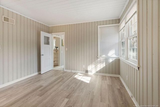 spare room with crown molding and light hardwood / wood-style floors