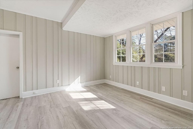 unfurnished room featuring a textured ceiling and light hardwood / wood-style flooring