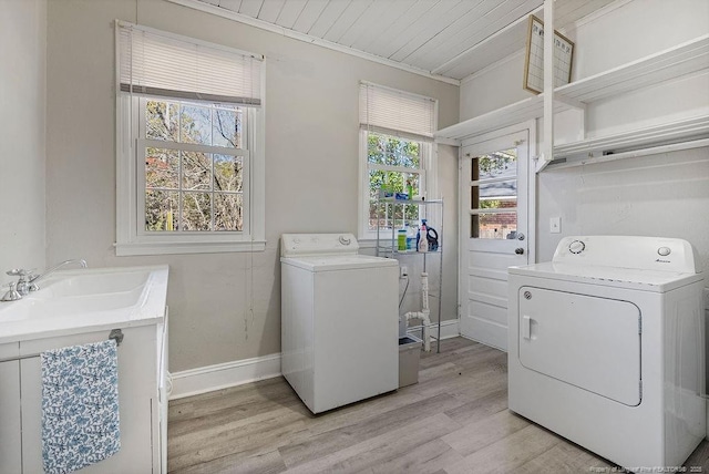 laundry room with independent washer and dryer, sink, light hardwood / wood-style flooring, and wooden ceiling