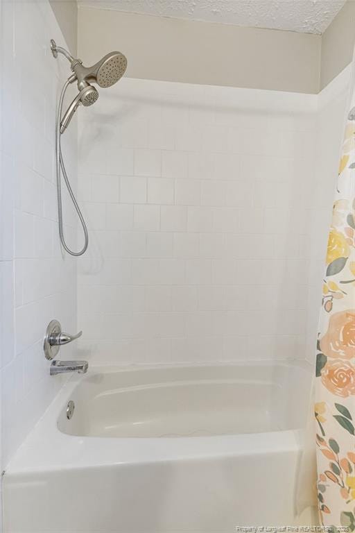 bathroom featuring shower / bathtub combination with curtain and a textured ceiling