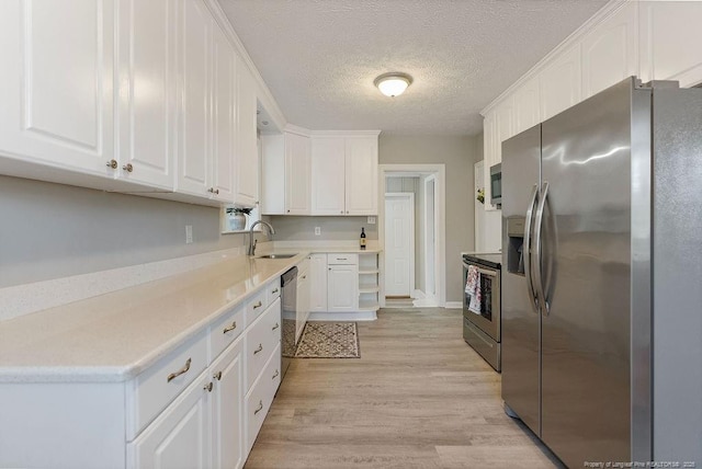 509 Vista Dr, Fayetteville, NC 28305 - kitchen featuring appliances with stainless steel finishes, a sink, white cabinets, light wood finished floors, and a textured ceiling