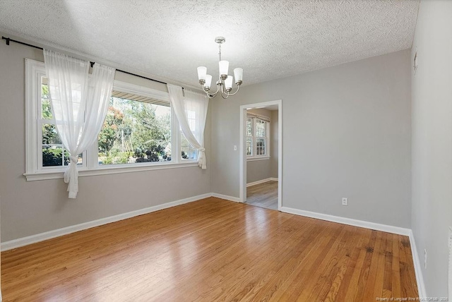 509 Vista Dr, Fayetteville, NC 28305 - empty room featuring a chandelier, light wood-style flooring, a textured ceiling, and baseboards