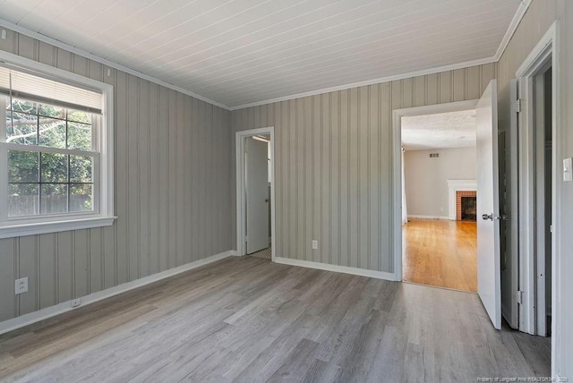 509 Vista Dr, Fayetteville, NC 28305 - unfurnished room featuring wood finished floors, crown molding, a brick fireplace, and baseboards