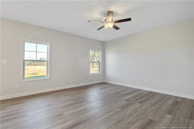 spare room featuring ceiling fan, baseboards, and wood finished floors