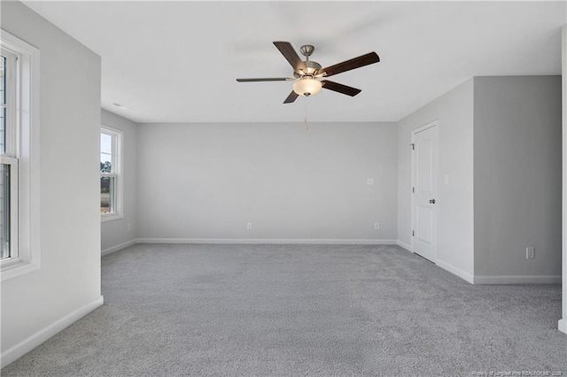 spare room with ceiling fan, carpet flooring, and baseboards