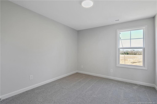 carpeted empty room featuring visible vents and baseboards