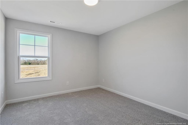 unfurnished room with carpet, visible vents, and baseboards