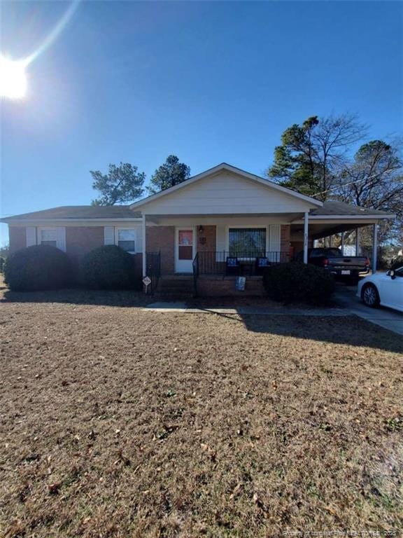 ranch-style house featuring a carport and covered porch