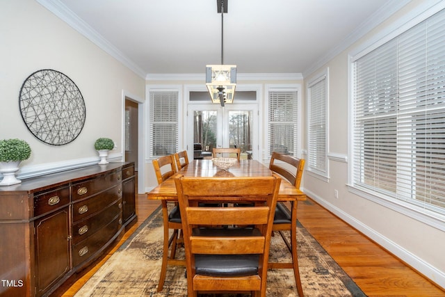 dining area with crown molding and light wood-type flooring