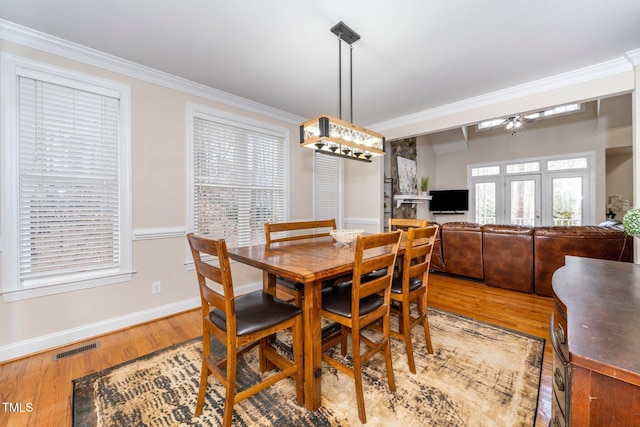 dining room with hardwood / wood-style floors and ornamental molding