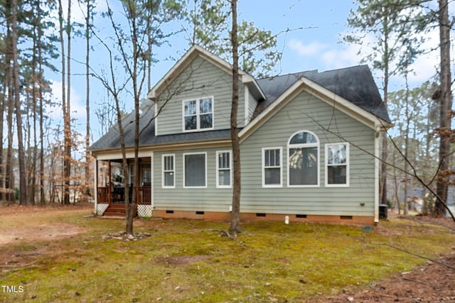 rear view of property featuring a yard and covered porch