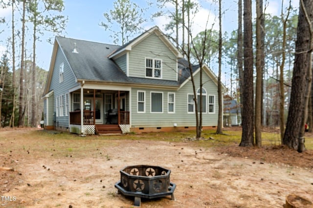 back of house with an outdoor fire pit and a sunroom