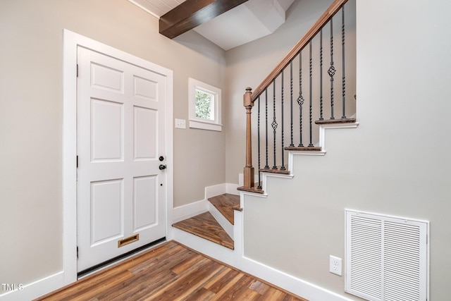 foyer entrance with wood-type flooring and beamed ceiling