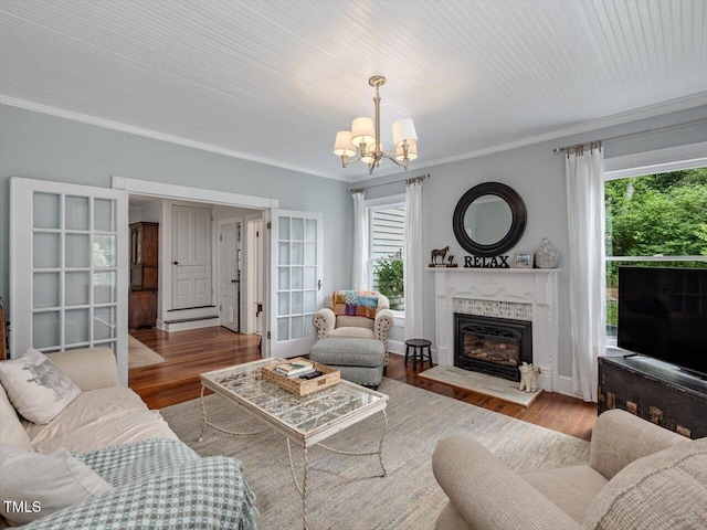 967 Bynum Rd, Pittsboro, NC 27312 - living area featuring a chandelier, ornamental molding, a glass covered fireplace, wood finished floors, and healthy amount of natural light