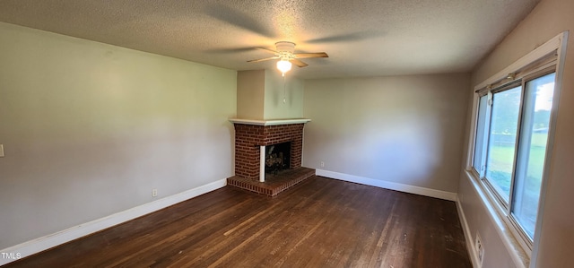 unfurnished living room with a brick fireplace, a textured ceiling, dark hardwood / wood-style floors, and ceiling fan