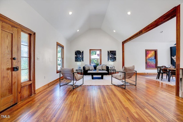 living room with high vaulted ceiling and light wood-type flooring