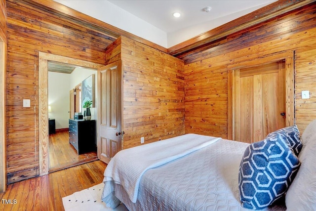 bedroom with wooden walls and wood-type flooring