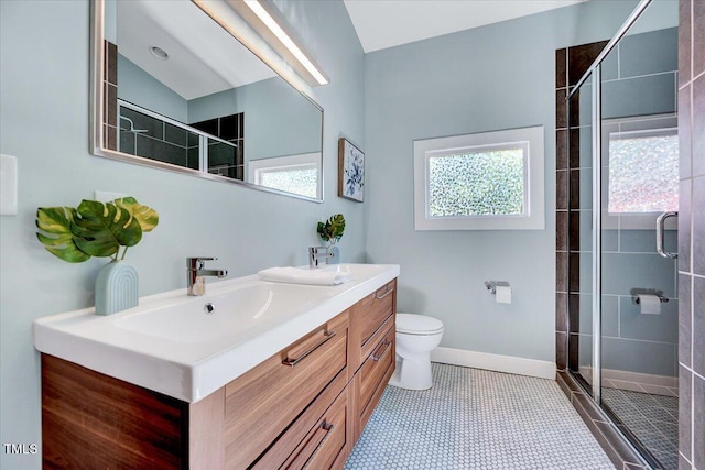 bathroom featuring vanity, tile patterned flooring, toilet, and walk in shower