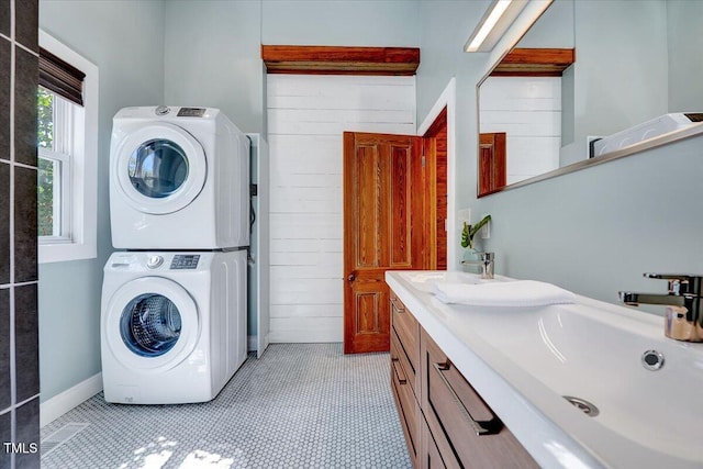 laundry area with stacked washer / dryer and sink