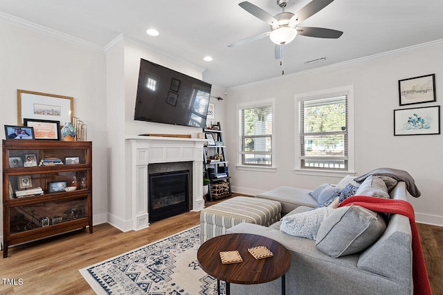 living room with ceiling fan, ornamental molding, and light hardwood / wood-style floors