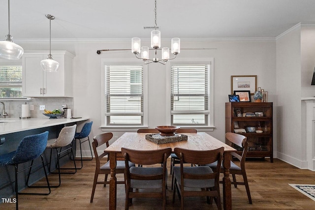 dining area featuring ornamental molding, dark hardwood / wood-style flooring, and a notable chandelier