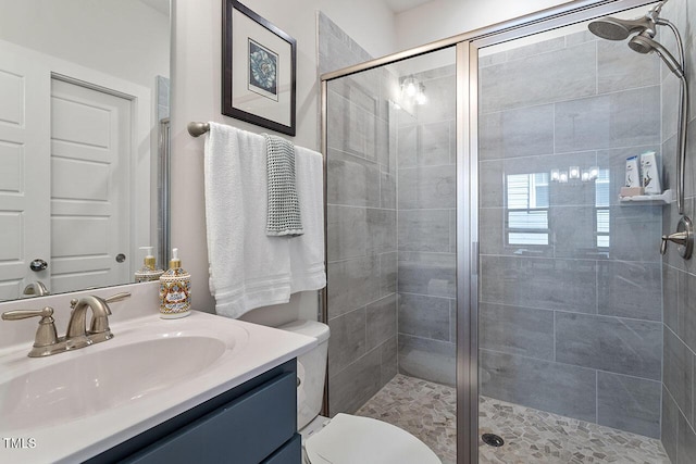 bathroom with an enclosed shower, vanity, and toilet