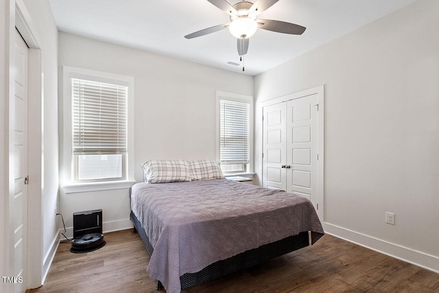 bedroom with wood-type flooring, ceiling fan, and a closet