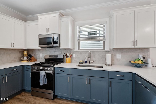 kitchen with white cabinetry, appliances with stainless steel finishes, blue cabinets, and sink