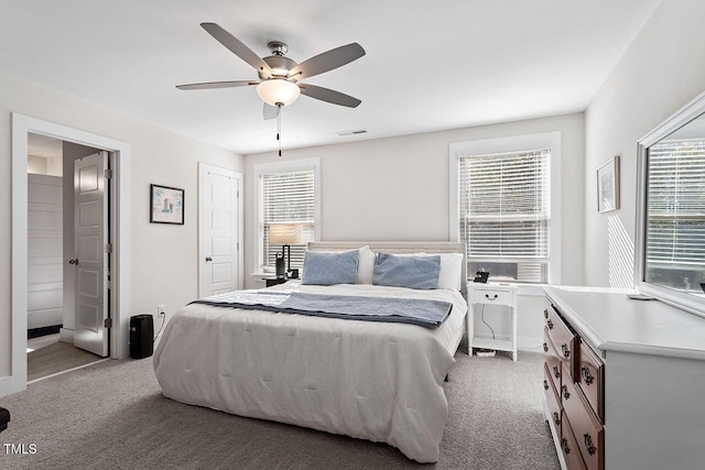 carpeted bedroom featuring ceiling fan and ensuite bath