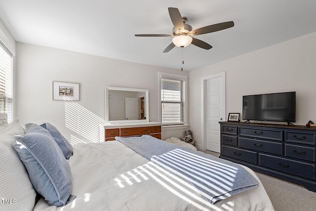 bedroom with ceiling fan, light colored carpet, and multiple windows