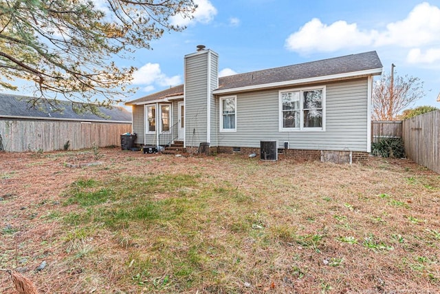 rear view of property with a lawn and central air condition unit