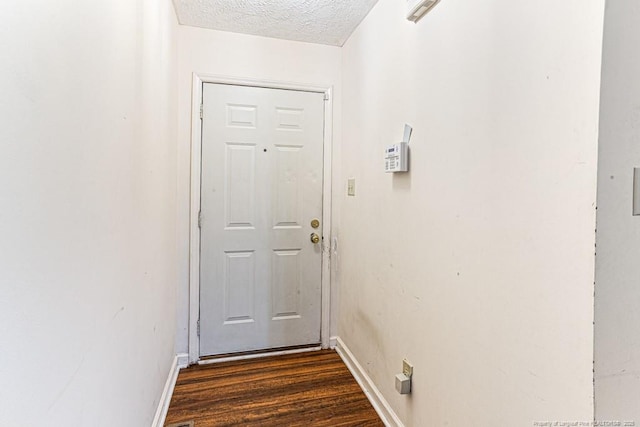 entryway featuring dark wood-type flooring and a textured ceiling