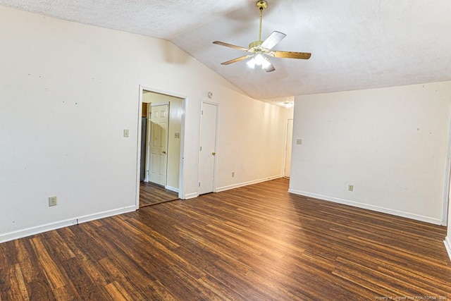 empty room with dark wood-type flooring, ceiling fan, vaulted ceiling, and a textured ceiling