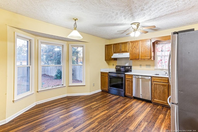 kitchen with pendant lighting, dark hardwood / wood-style flooring, a textured ceiling, and appliances with stainless steel finishes