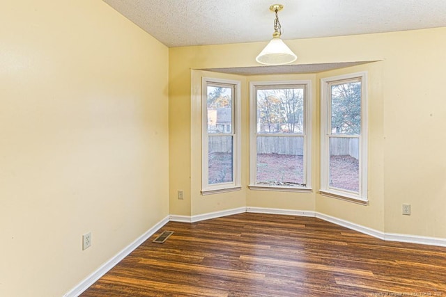 spare room with dark wood-type flooring and a textured ceiling