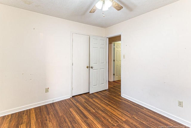 spare room with dark wood-type flooring, a textured ceiling, and ceiling fan