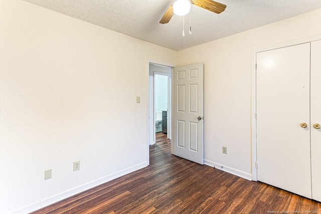 unfurnished bedroom with ceiling fan, dark wood-type flooring, and a textured ceiling