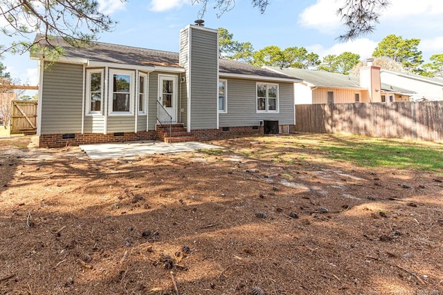 back of house with cooling unit, fence, a chimney, entry steps, and crawl space