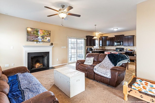 living room featuring ceiling fan, sink, and light carpet