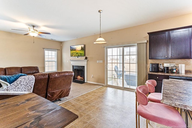 living room featuring ceiling fan and a high end fireplace