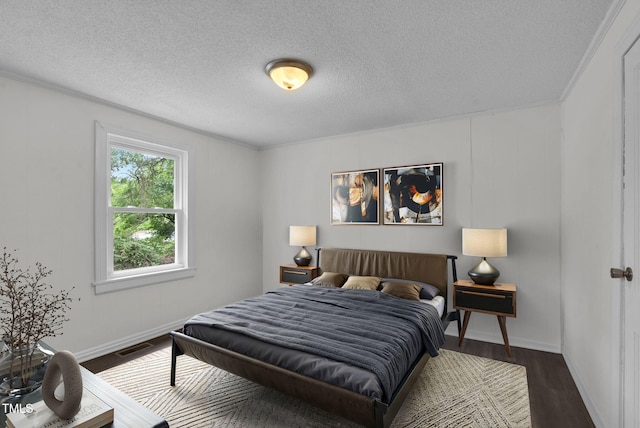 bedroom with dark wood-style flooring, a textured ceiling, and baseboards