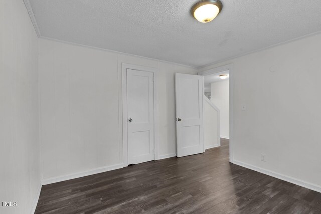unfurnished bedroom with a textured ceiling, dark wood finished floors, a closet, and baseboards