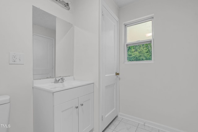 half bath featuring toilet, vanity, marble finish flooring, and baseboards