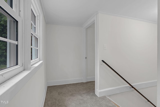 corridor featuring carpet floors, plenty of natural light, baseboards, and an upstairs landing