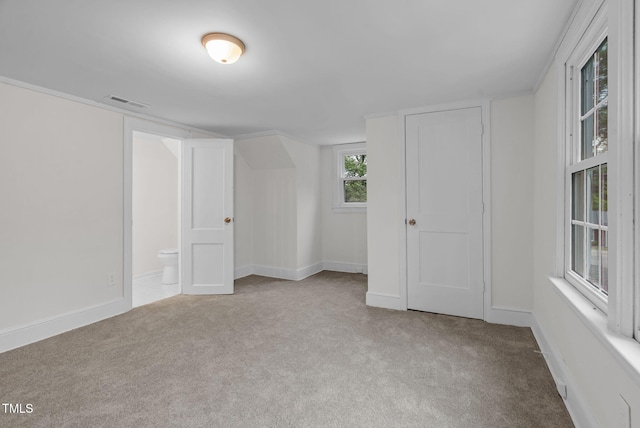 unfurnished bedroom with carpet, baseboards, and connected bathroom