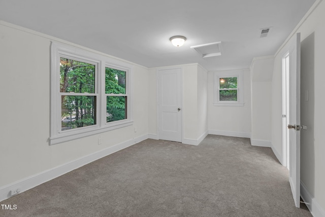 unfurnished bedroom featuring attic access, carpet, and baseboards