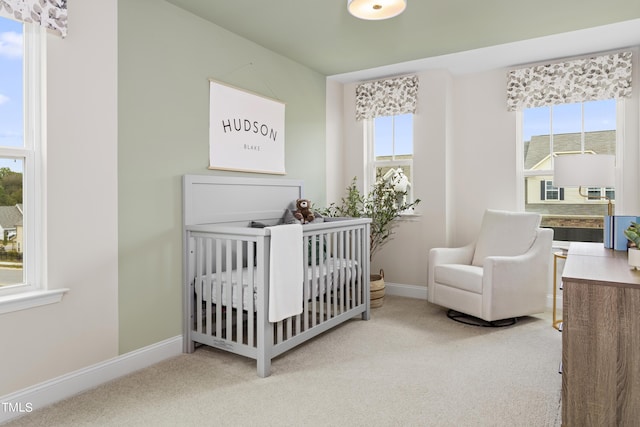 carpeted bedroom with a nursery area