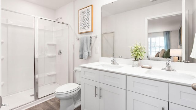 bathroom featuring an enclosed shower, vanity, wood-type flooring, and toilet